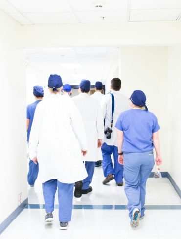 group of doctors walking on hospital hallway